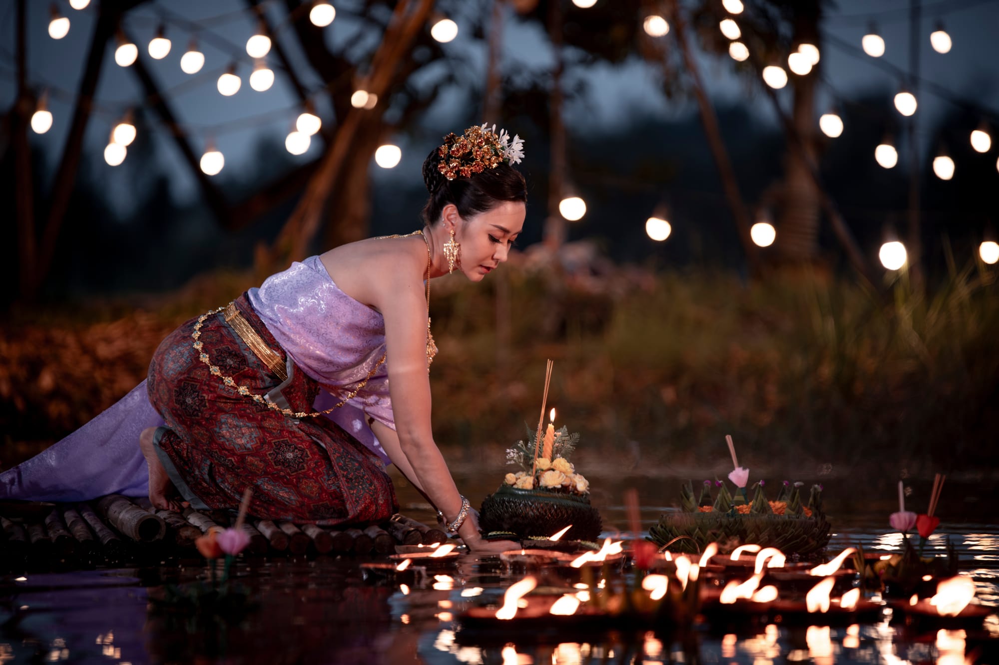 Floating krathongs with candles on water during Loi Krathong festival in Thailand